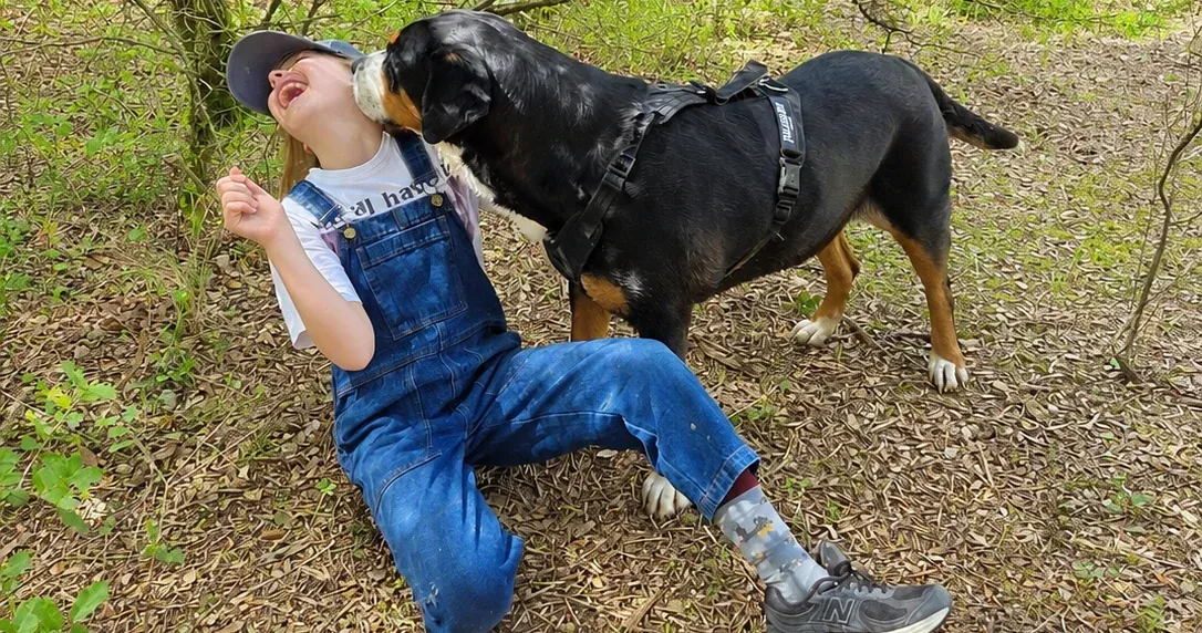 Une personne partage un moment calme avec un chien dans l’herbe